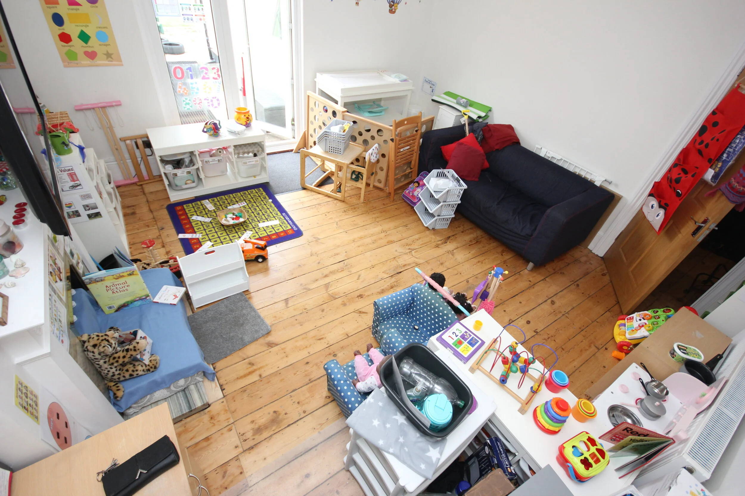 Indoor learning area with wooden toys, books, and sensory play materials in South Norwood childcare setting.