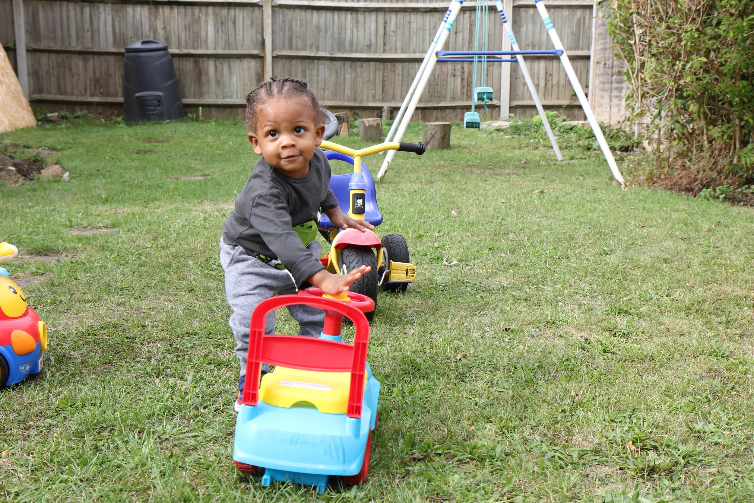 Children exploring the outdoor garden with trikes at Little Seeds."