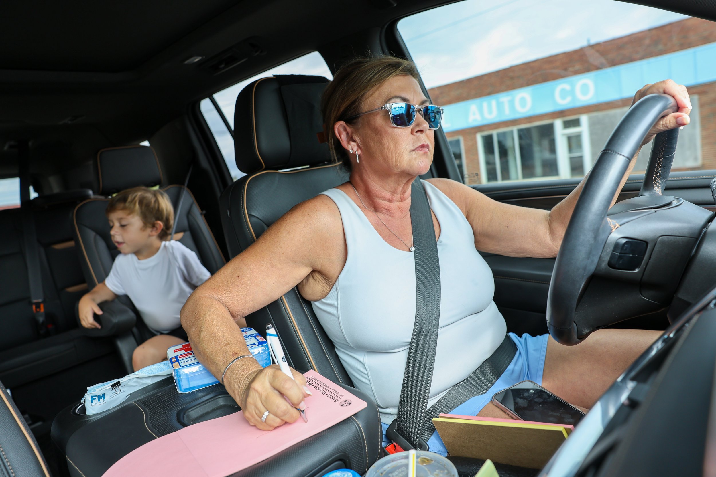 Tina multitasks by writing a to-do list while driving her two grandchildren — Baker, 4, and Woods, 5 — to McDonald's for breakfast. She cared for them for a week while her youngest daughter moved homes in Tennessee.