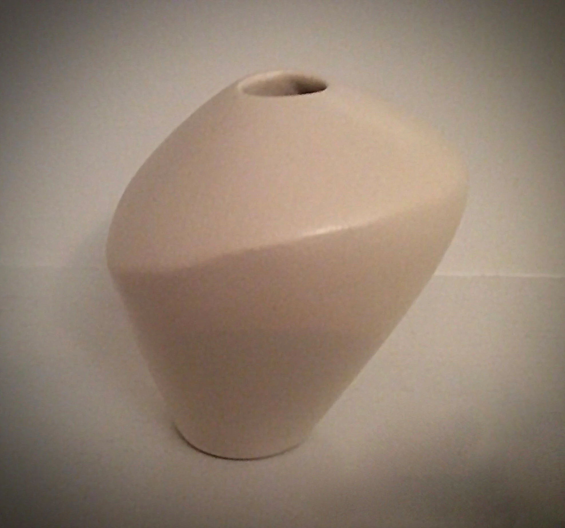 Small white ceramic vessel with terra sigillata surface.