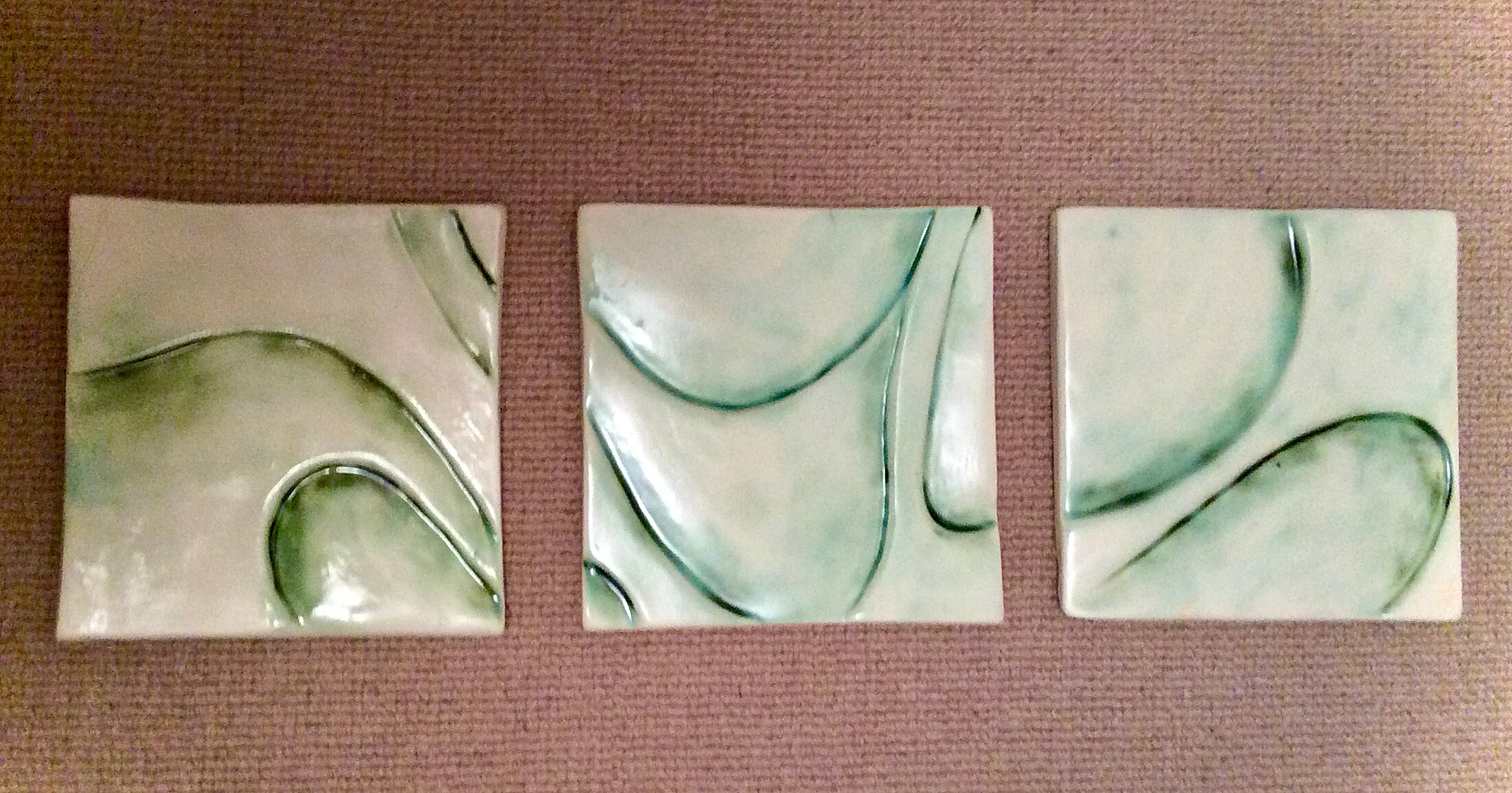 Three-piece wall hanging. Oxide under clear glaze.