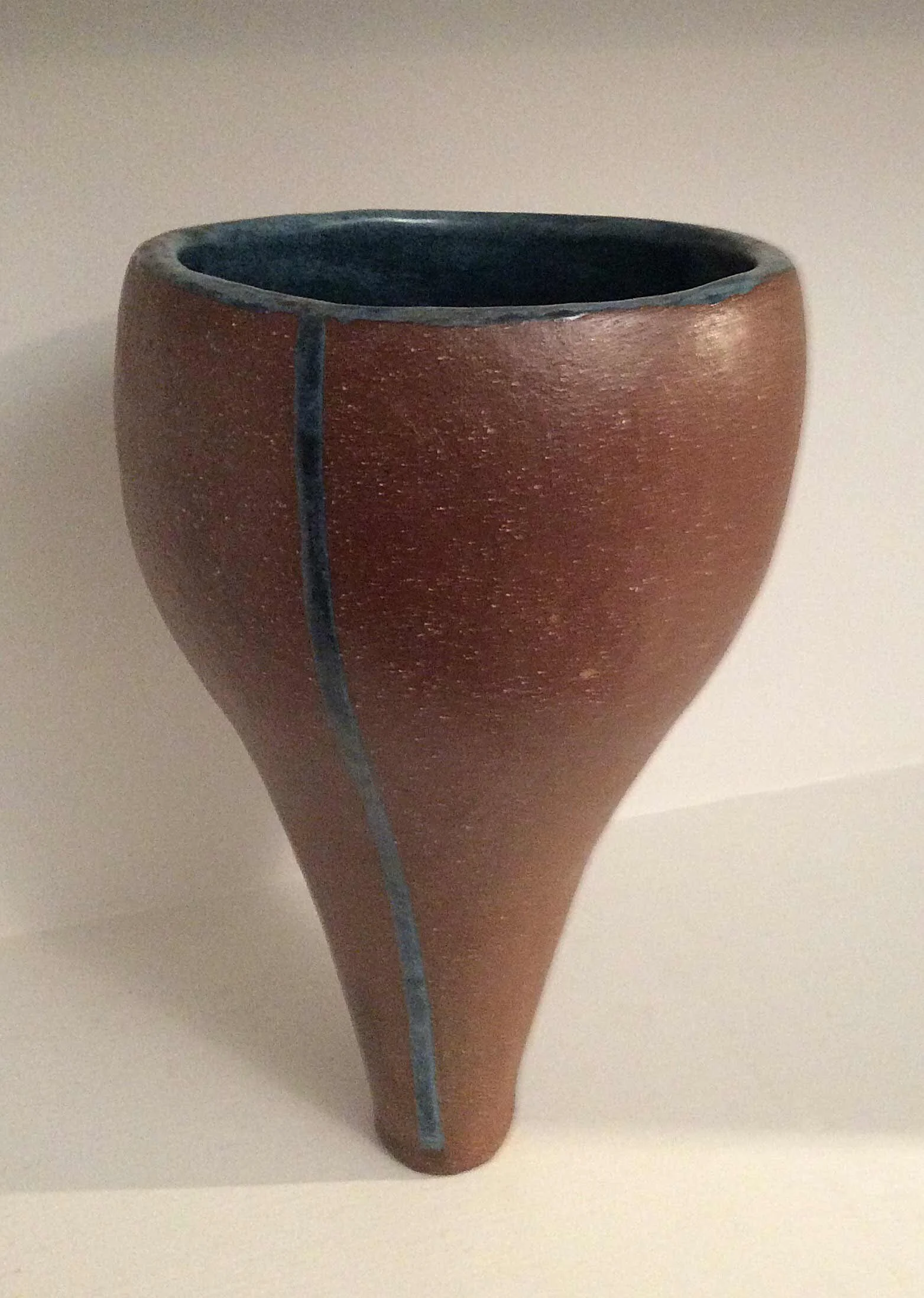 Vessel with blue stripe. Terra cotta surface with glaze stripe.