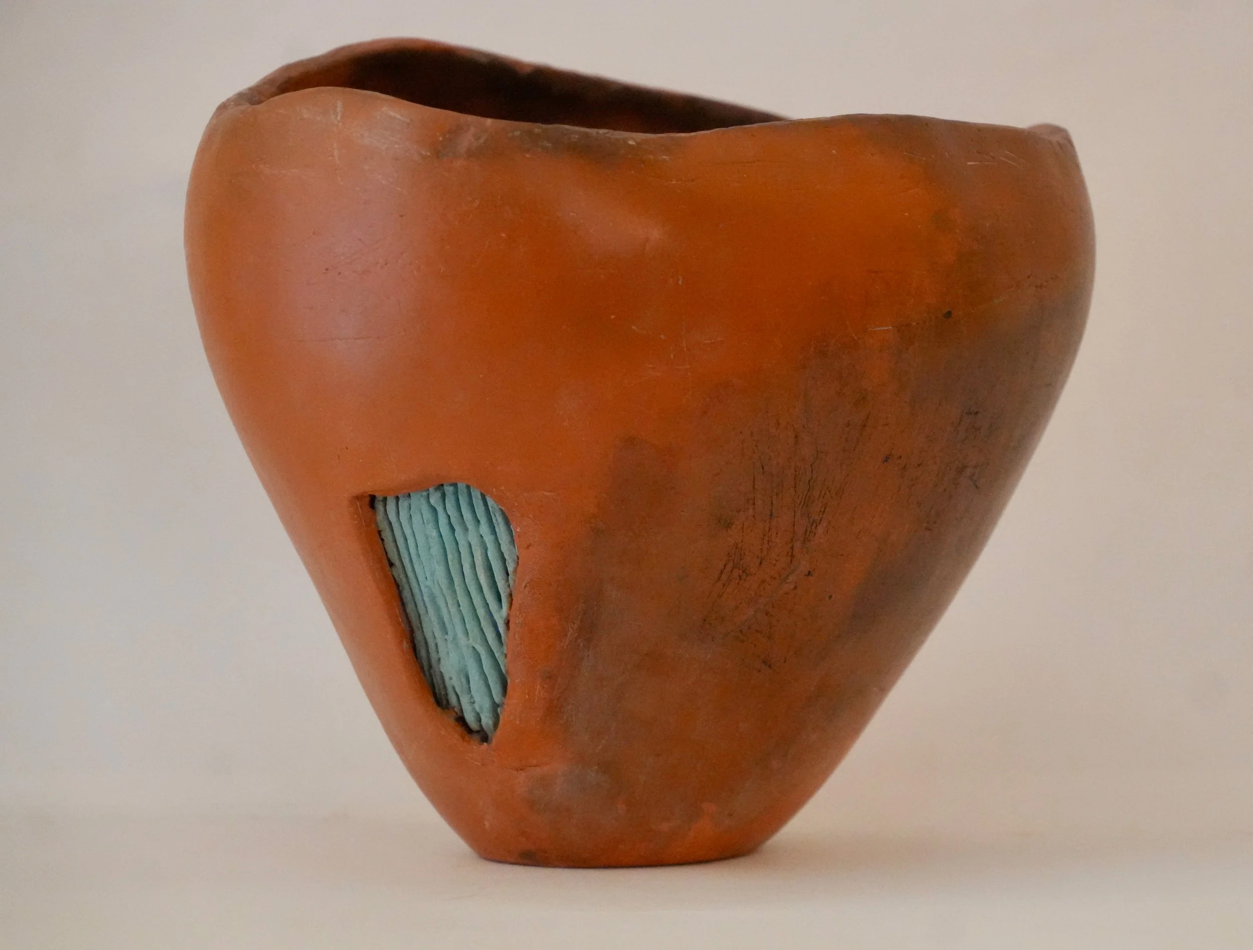 Asymmetrical smoke fired vessel with a patch