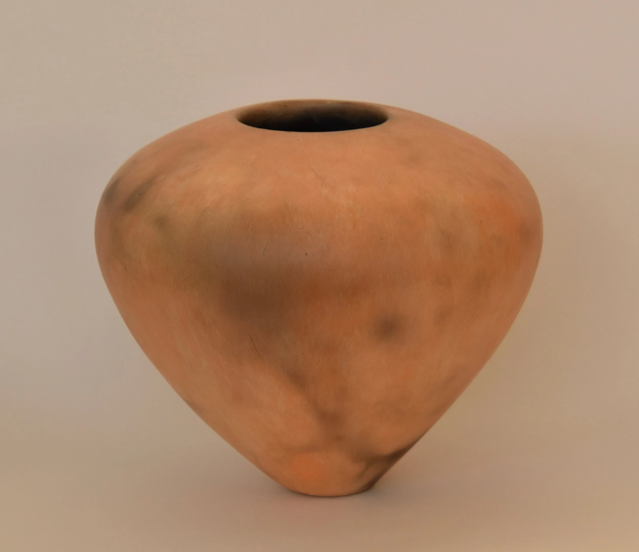 Shades of peach colored smoke fired vessel
