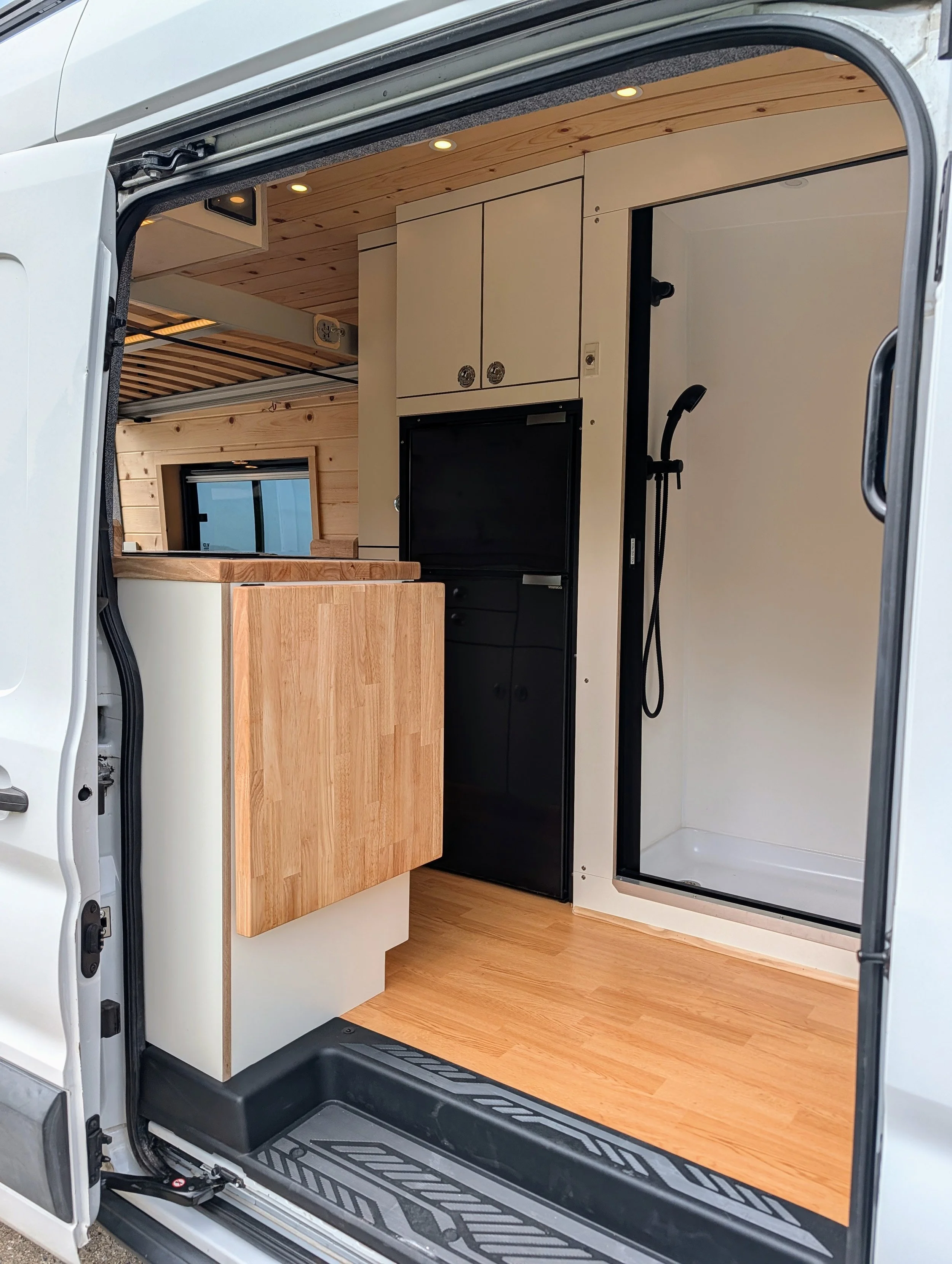Custom Ford Transit Conversion, bed lift, custom cabinetry, shower, nautaulis door