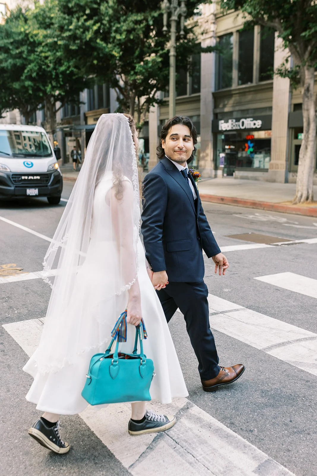 Bride and groom crossing the street in downtown Los Angeles after their ceremony