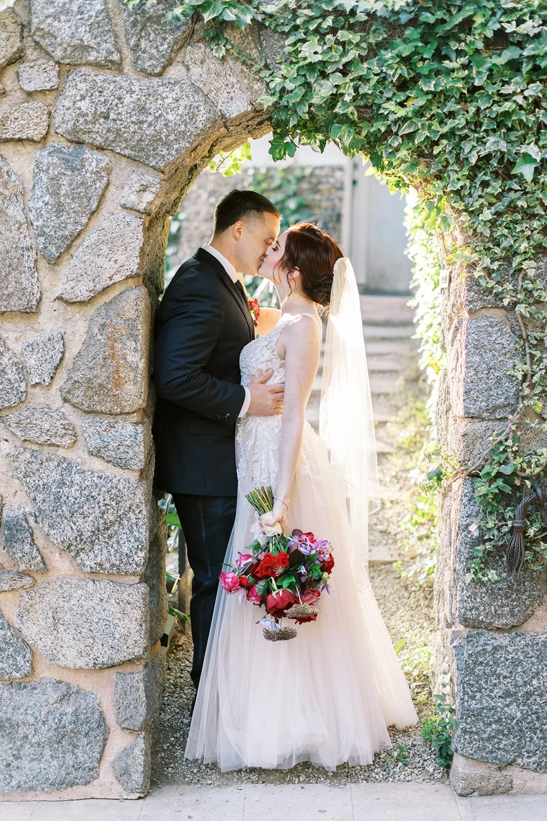 Bride and Groom kissing in an archway at the Houdini Estate, Los Angeles