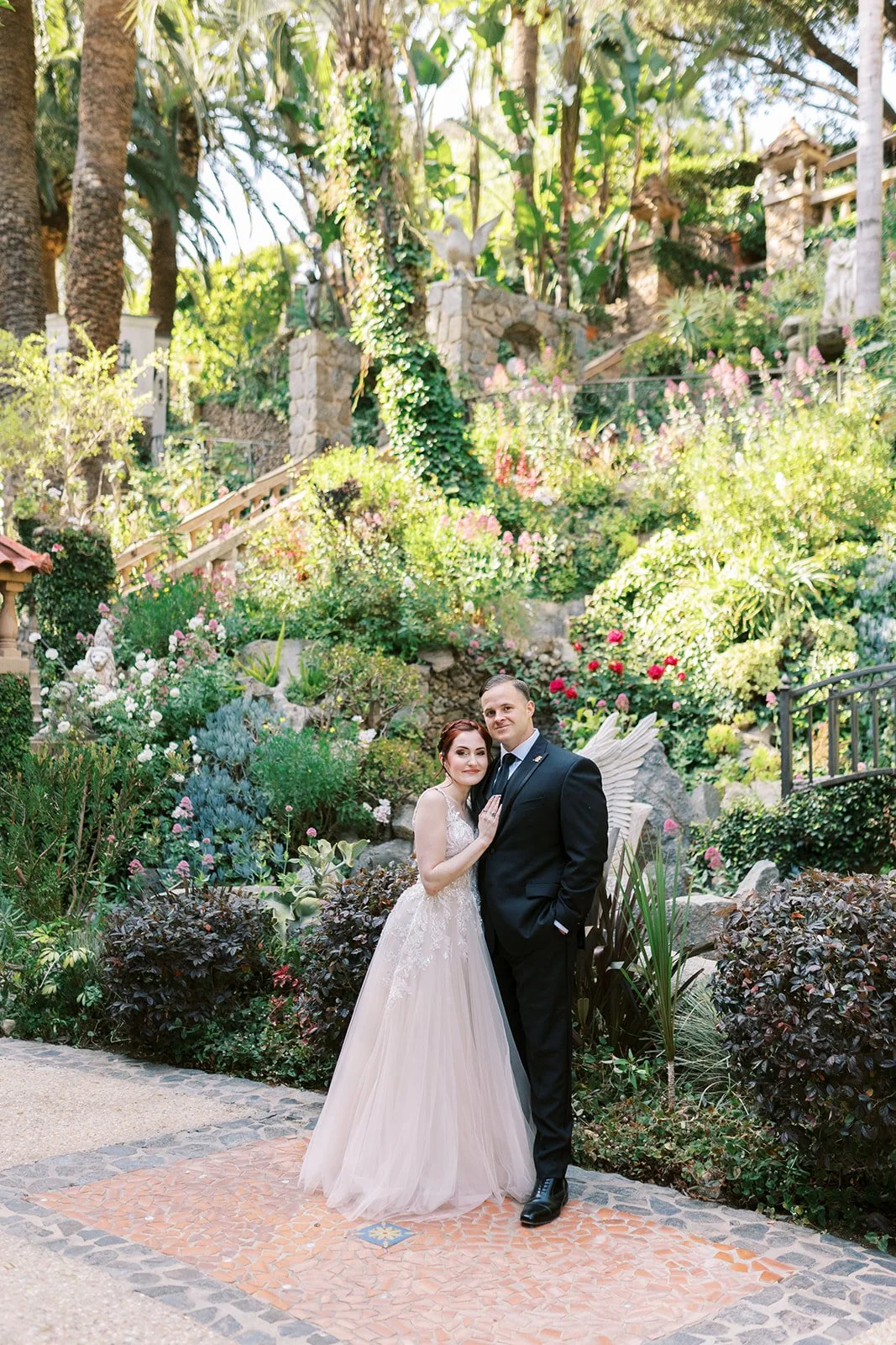 Bride and groom posing in front of the terraced gardens at the Houdini Estate
