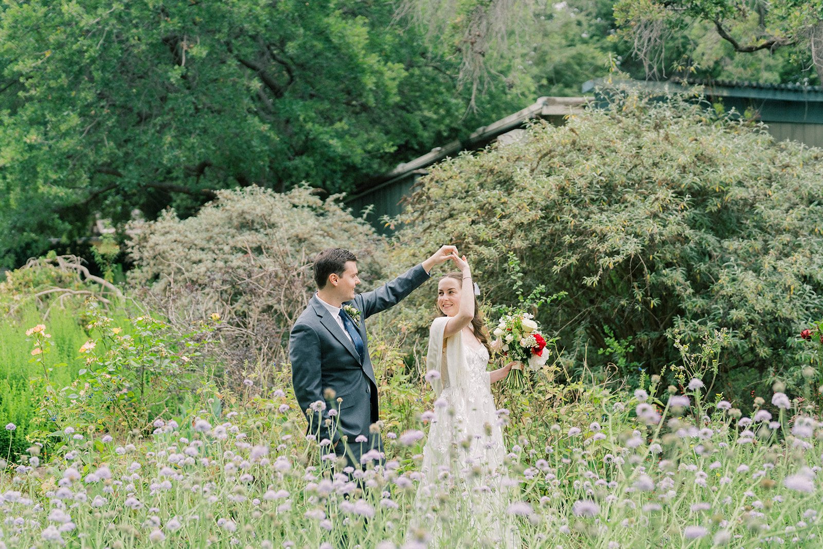 Groom twirling the bride through the flower fields after their elopement