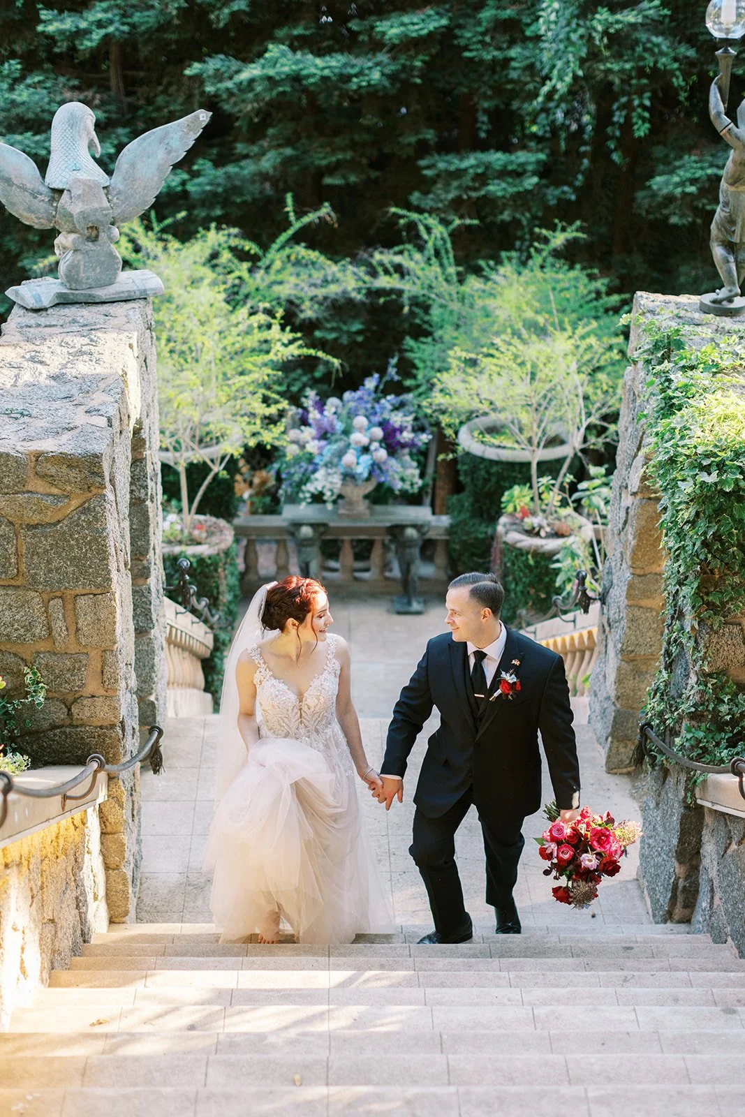 Bride and groom gazing at each other as they walk hand in hand up the steps of the Houdini Estate
