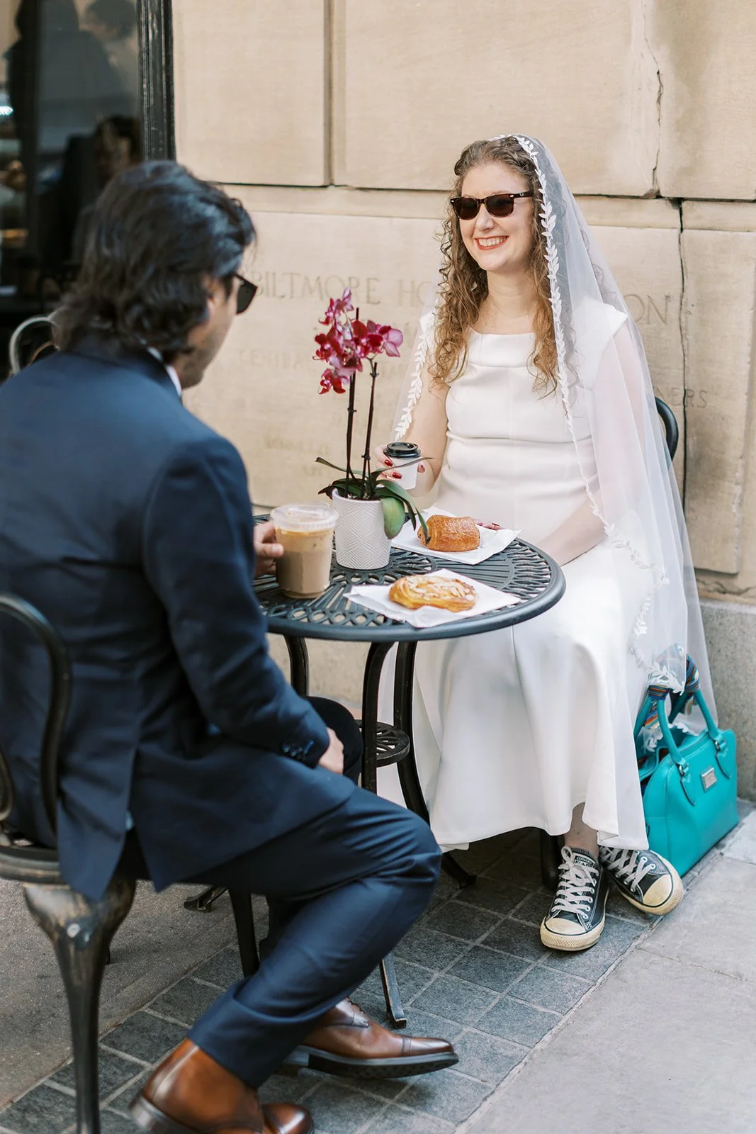 Bride and groom sharing coffee and pastries after their sunrise elopement