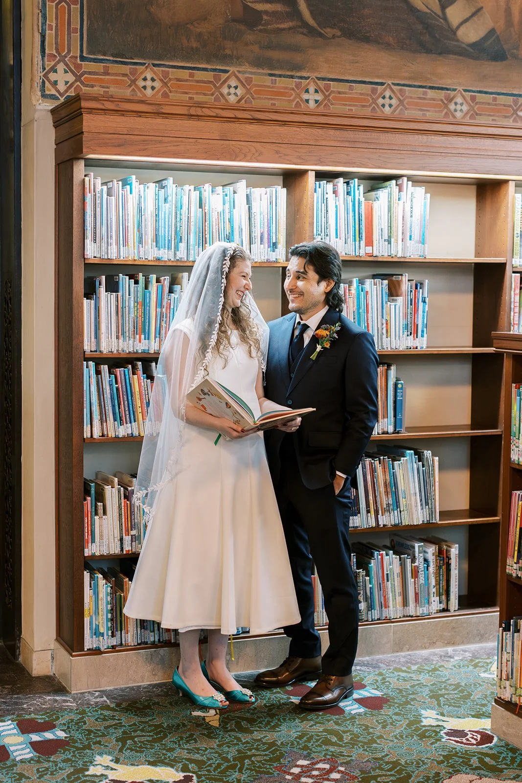 Bride and groom browsing the bookshelves together on their wedding day
