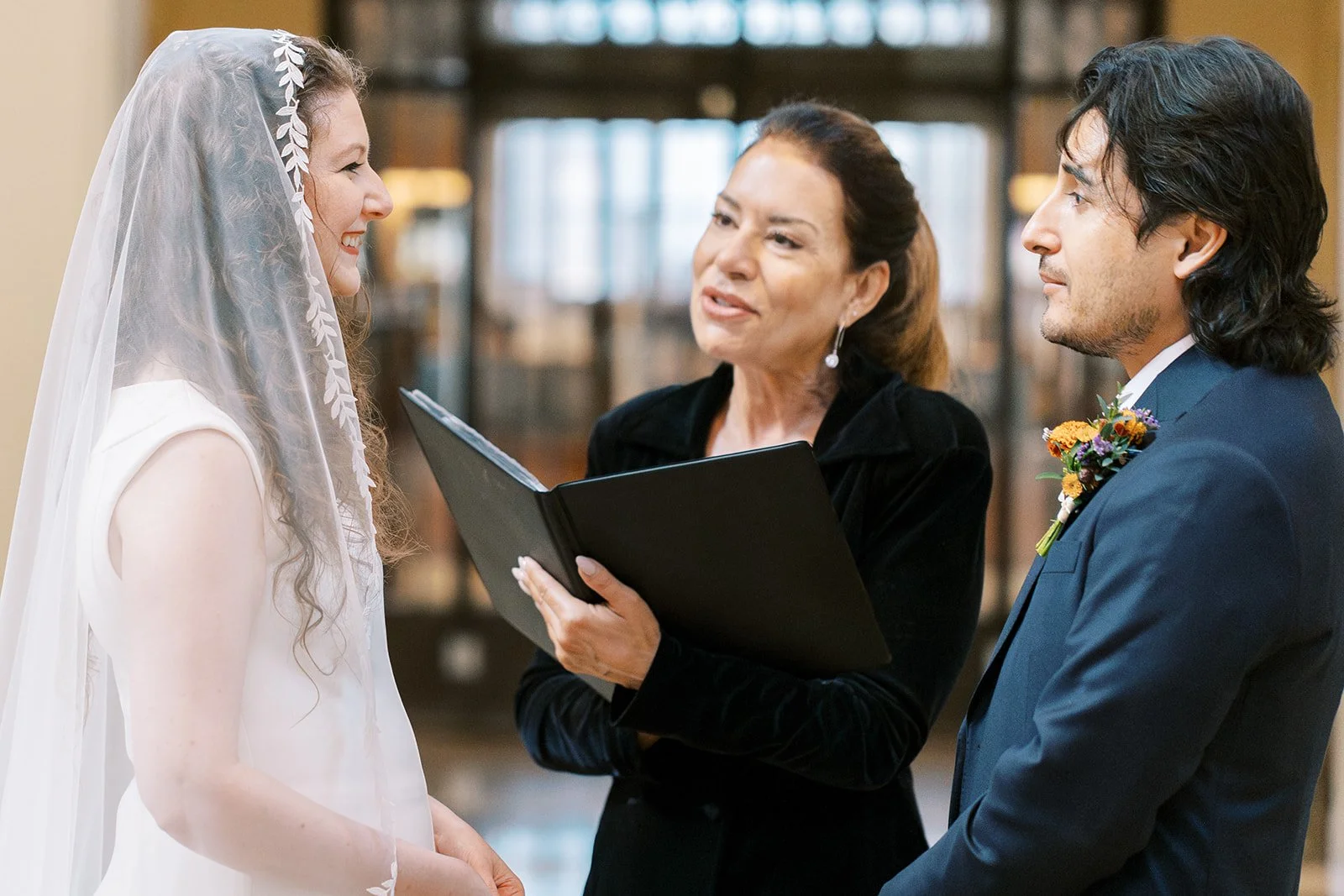 Couple exchanging vows during their ceremony in the rotunda of the Los Angeles Central Library.