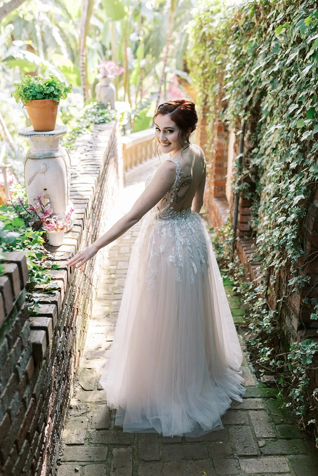 Portrait of the bride looking over her shoulder on a walkway beside the house at the Houdini Estate