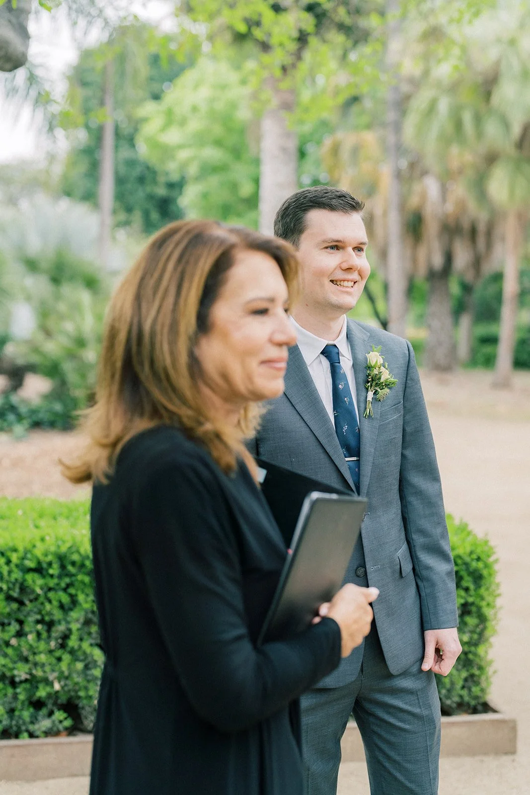 Groom and officiant watching the bride approach the altar at the Fullerton Arboretum