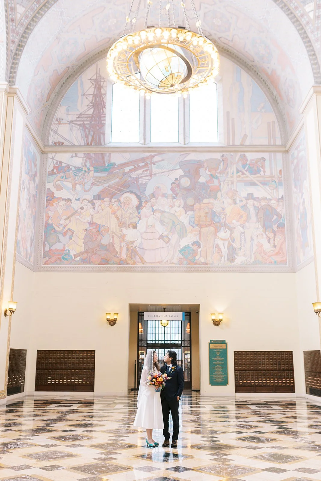 Bride and groom beneath the painted ceiling of the Central Library rotunda in downtown Los Angeles.