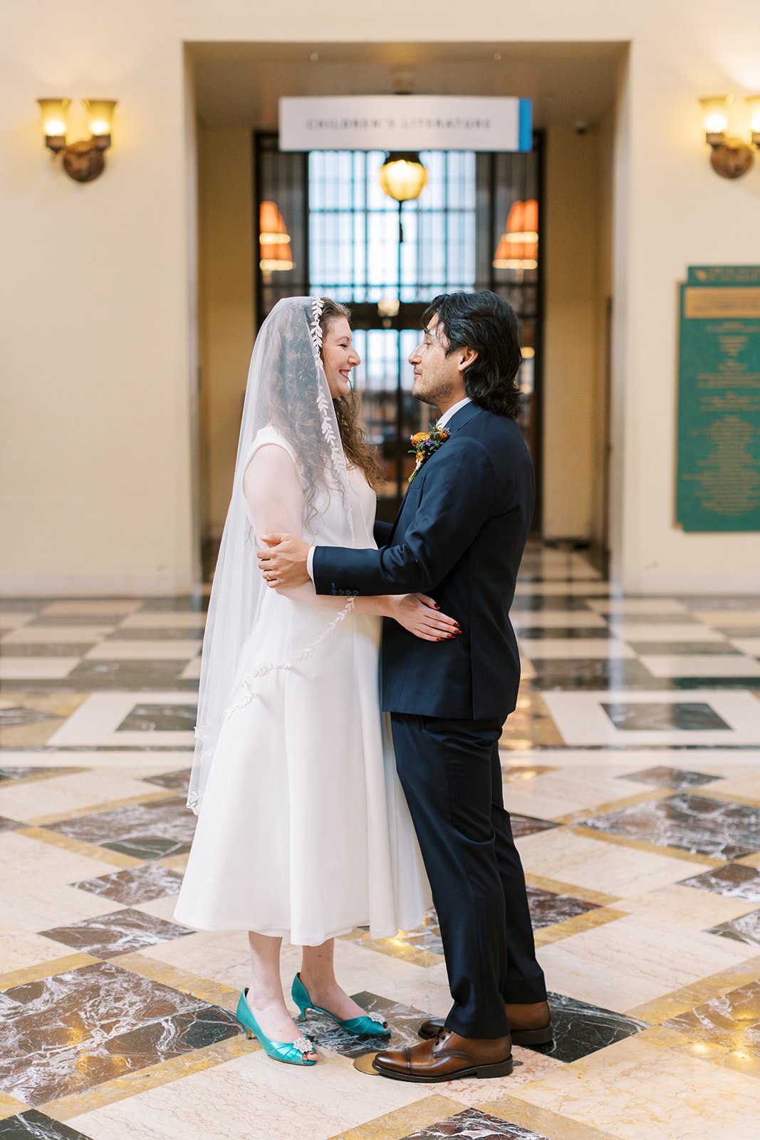 Couple leaning in for their first kiss at their intimate library wedding.