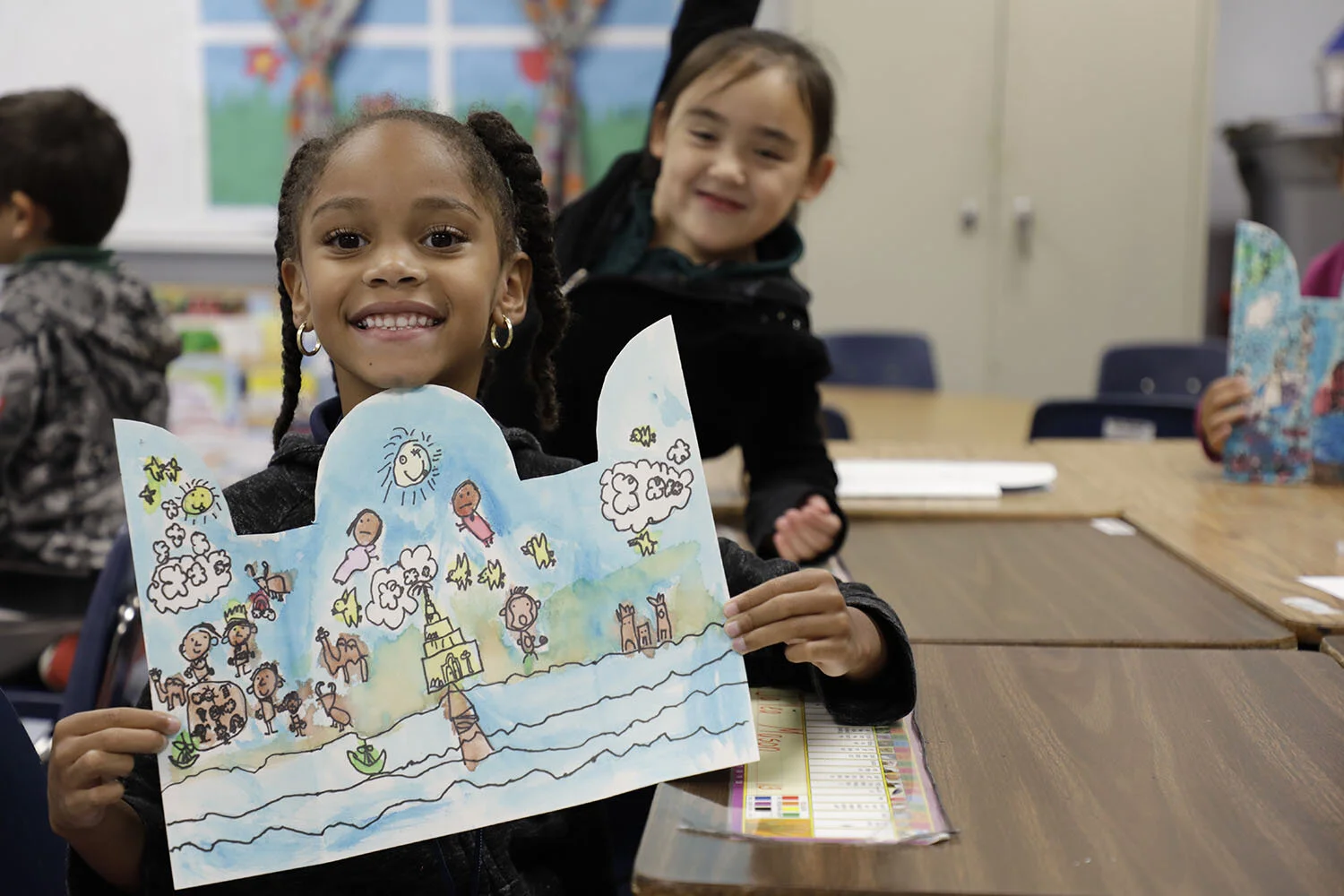 Arts-Integrated Professional Development: a young student proudly displays her water-resist technique on her colorful triptych.