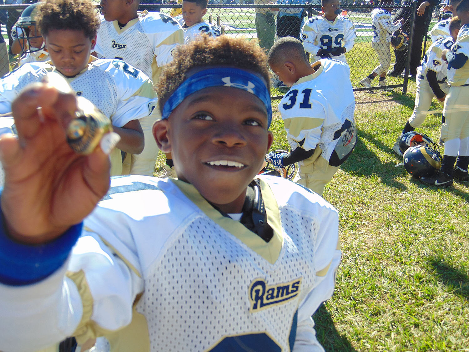  Afterschool and Summer Arts Enrichment Program: boy in football gear smiles at the camera.  
