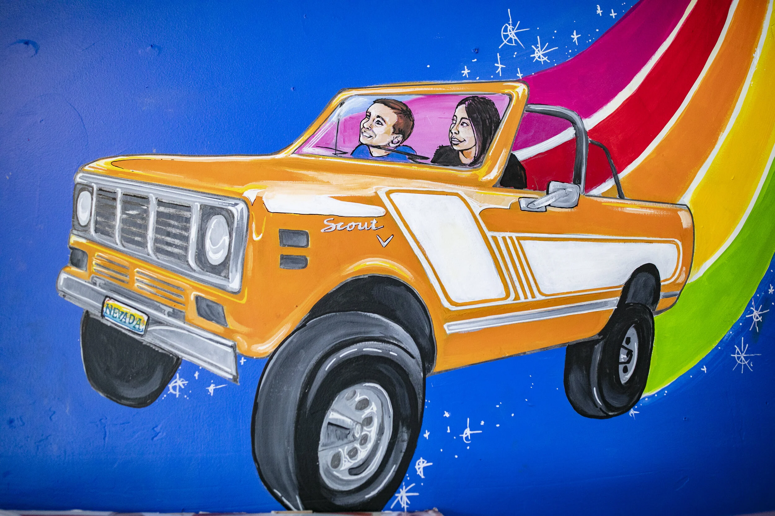 Childish Toy Shop indoor Mural in Santa Cruz, California — close up of a truck in space with a rainbow trail of stars behind it by local painter, Brittany Costanzo
