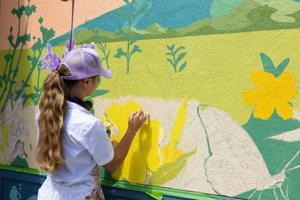 Santa Cruz local muralist hand painting a nature inspired mural at Bradley Elementary School in Santa Cruz, CA