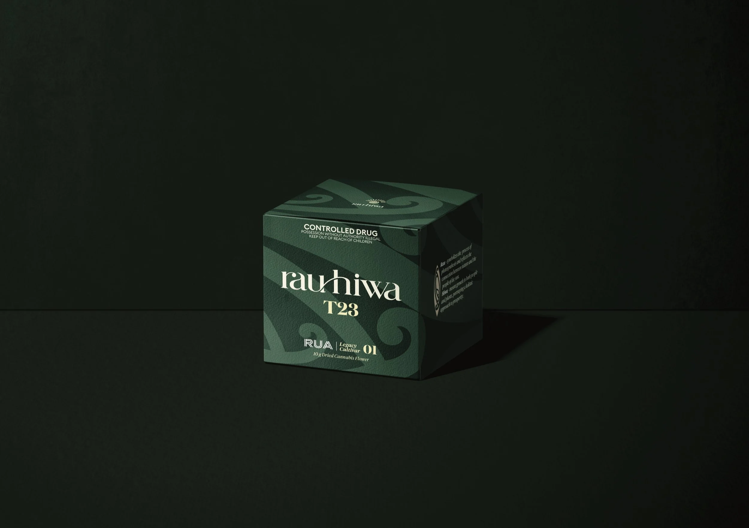 Green cannabis product package labeled 'rauhiwa T23' with controlled drug warning, placed on a dark surface with a shadow cast to the right.