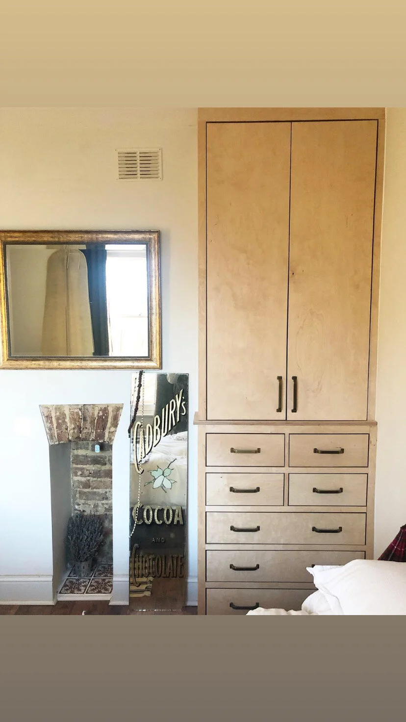 Interior of a room with a mirror, a cabinet, and a decorative niche in the wall.
