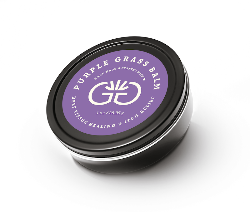 Strange Makes Purple Grass Balm in a closed black tin, an all-natural deep tissue healing and itch relief salve for muscles and skin care.