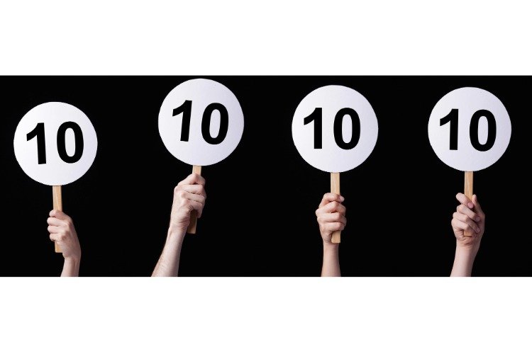 hands holding signs with all 10s as if a judging panel