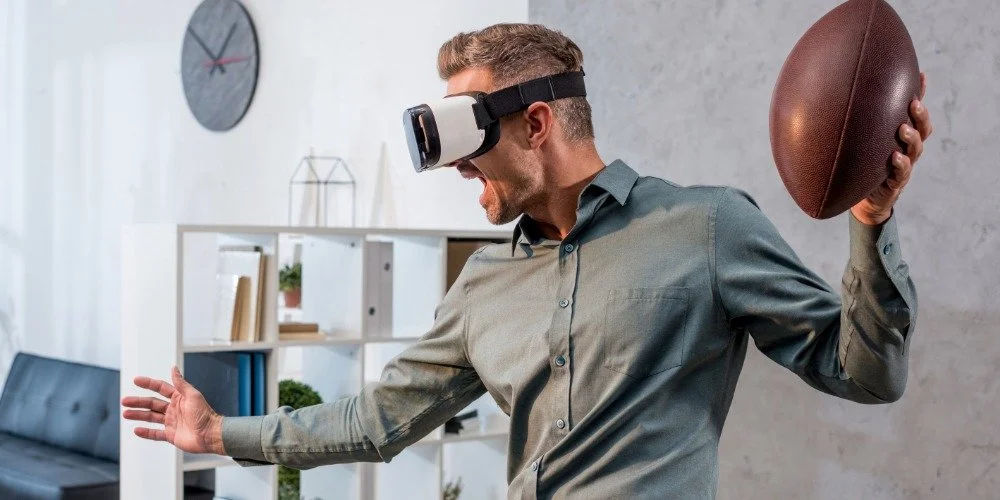 man wearing VR headset and holding a football