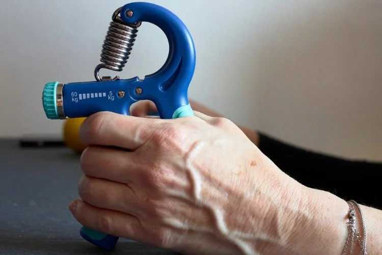 person squeezing grip trainer