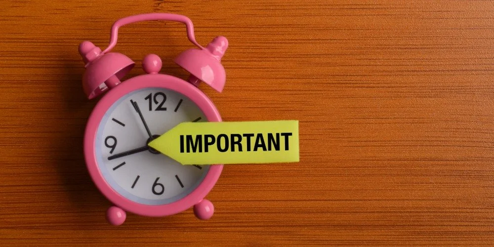 alarm clock with yellow tag that says important