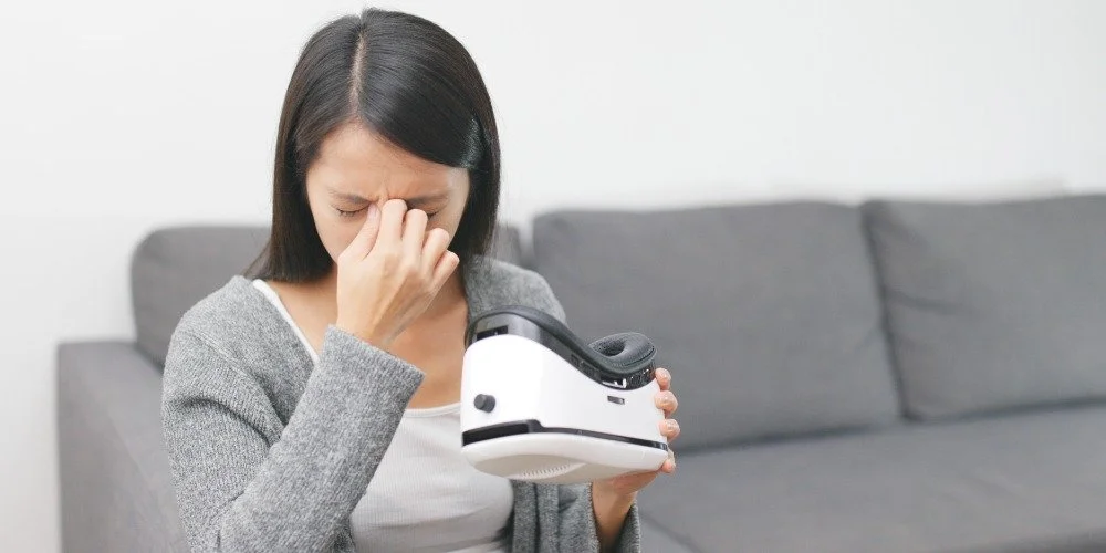 woman holding a VR headset holding her face
