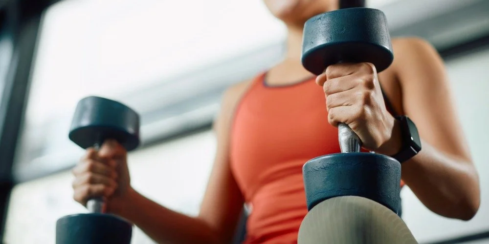 woman sitting down holding weights