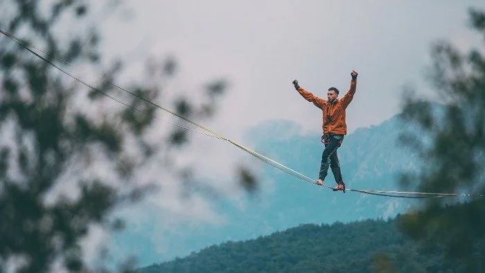 slackliner balancing high up in sky
