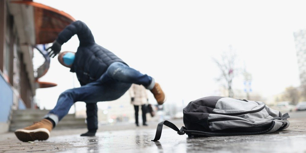man falls while slipping on ice twisting in the air