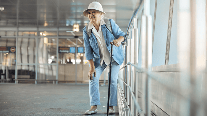older person with cane and knee pain