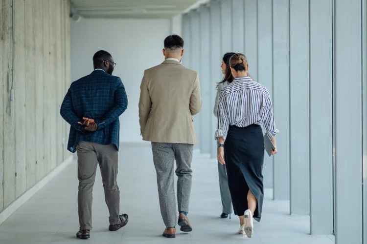 four people walking along a hallway