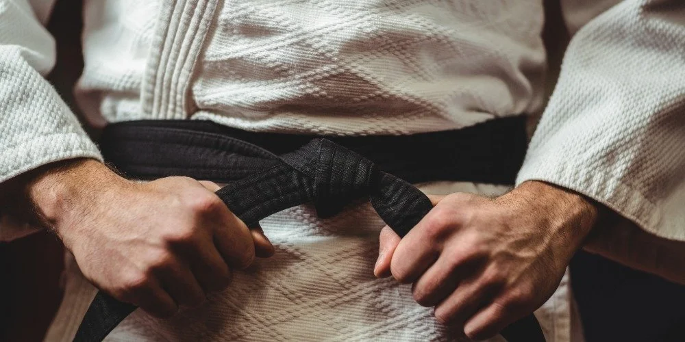 person pulling on martial arts belt