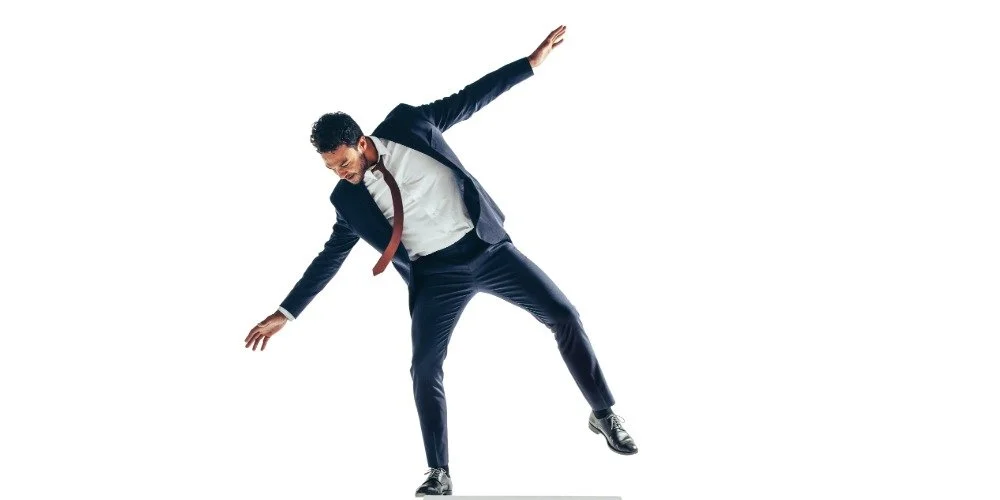 man losing balance on one leg and using his arms