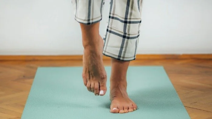 person performing a single leg balance on a yoga mat
