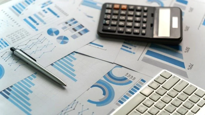 charts and graphs on paper with pen and calculator