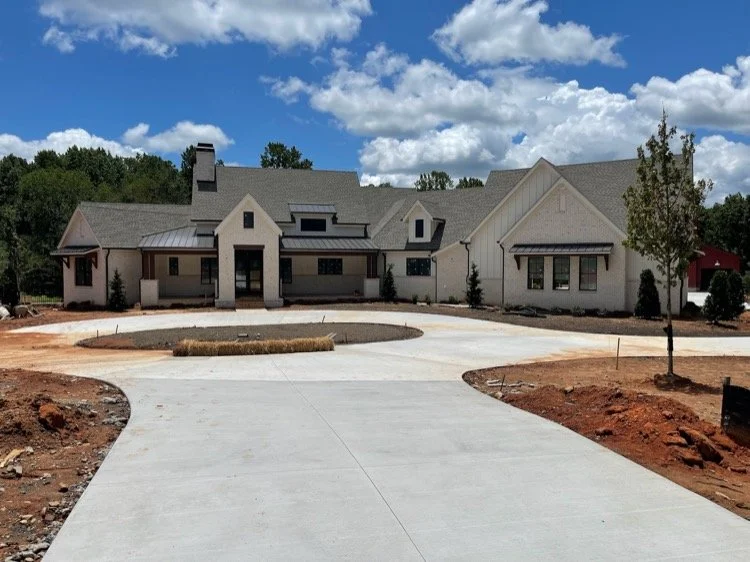 White House with Black Roof and newly paved driveway with landscaping still being done