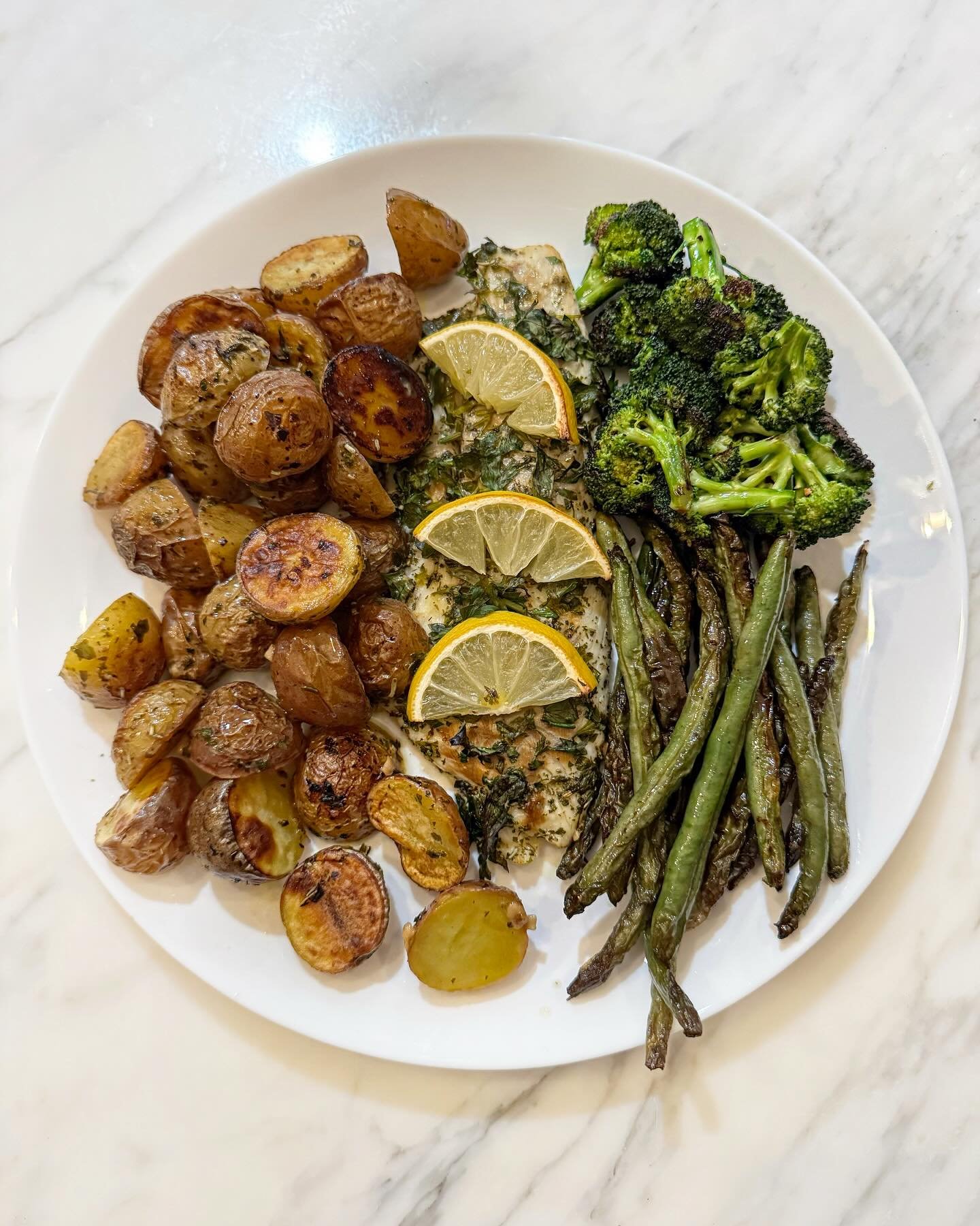 Lemon Roasted Branzino with Potatoes 🍋🐟🌿

Ingredients:
&bull;1.5 lemons squeezed (save a few lemon slices for fish)
&bull;2 lb creamer potatoes halved 
&bull;1 minced garlic clove 
&bull;Fish fillets (I used branzino any whitefish would work)
&bul