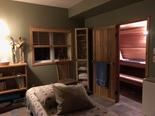 Cozy bedroom with private sauna room and wooden interior.