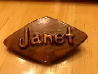 Handcrafted wooden name badge engraved with the name Janet, representing the personal hospitality and family heritage of the inn.