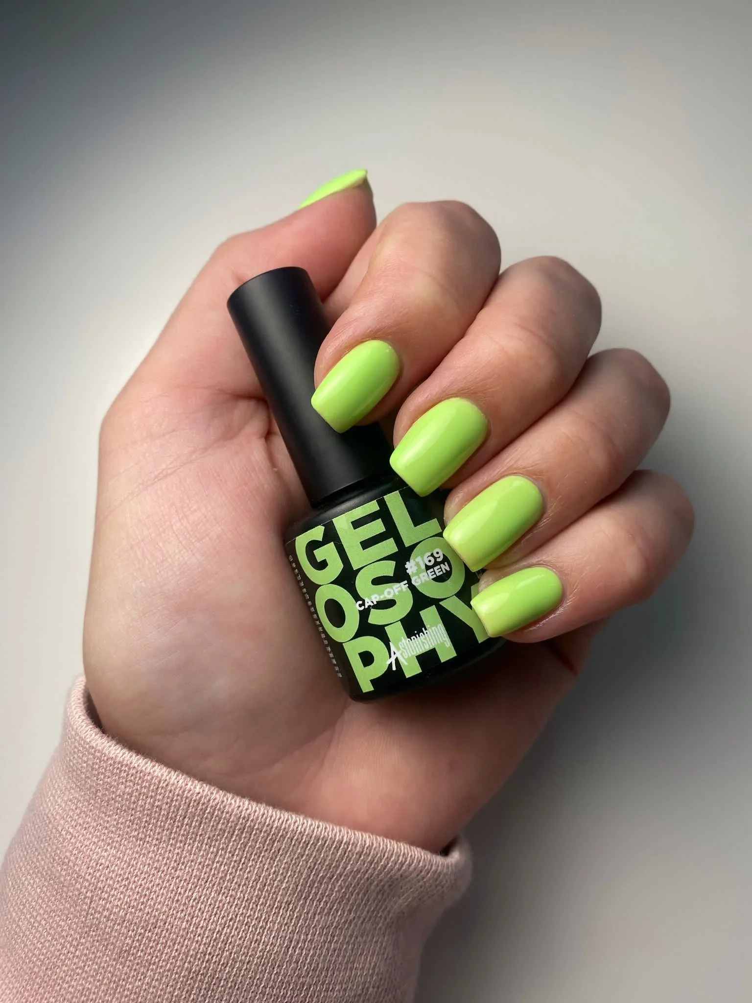 Hand holding Gelosophy #169 Cap-off Green neon lime gel polish bottle neon green nails