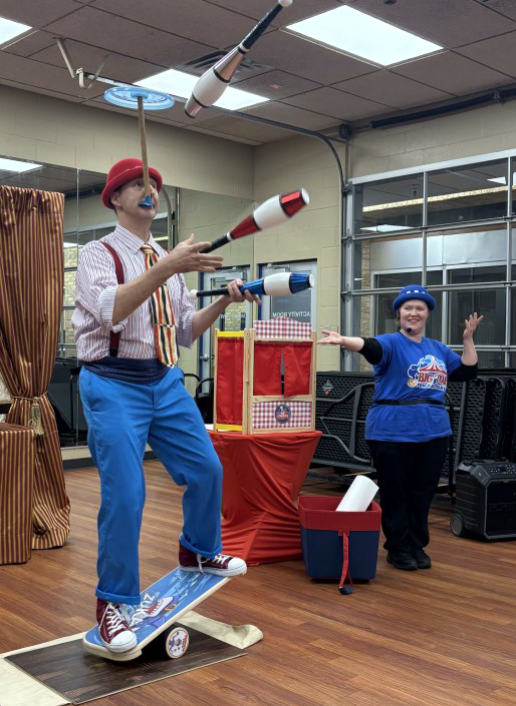 Two clowns perform a juggling act.