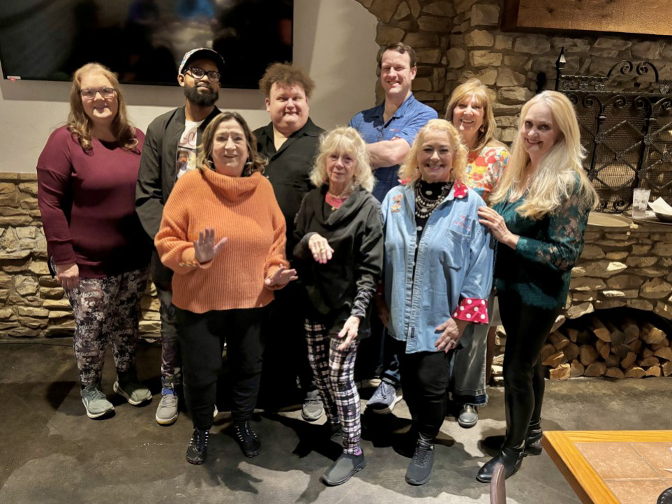A group of people standing in front of a fireplace