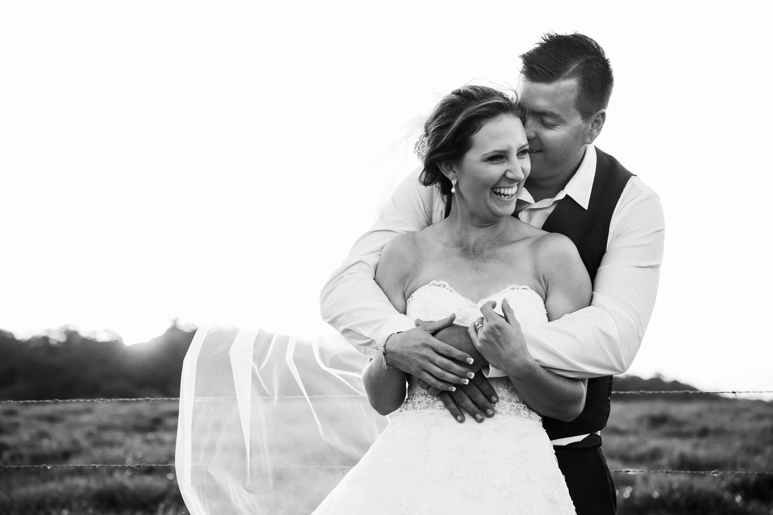 relaxed photo of bride and groom laughing at country wedding